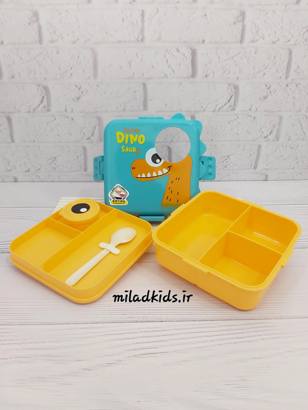 ظرف غذای کودک طرح دایناسوری رنگ آبی-نارنجی باز شده همراه با قاشق پلاستیکی، ظرف سس جداگانه و 4 قسمت برای غذا