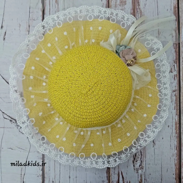 نمای بالا از کلاه لبه دار داخترانه حصیری توری گل و پاپیون دار رنگ زرد